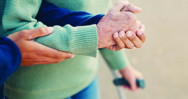 Photo illustrant les mains d'une personne âgée soutenues par les mains d'un adulte.
